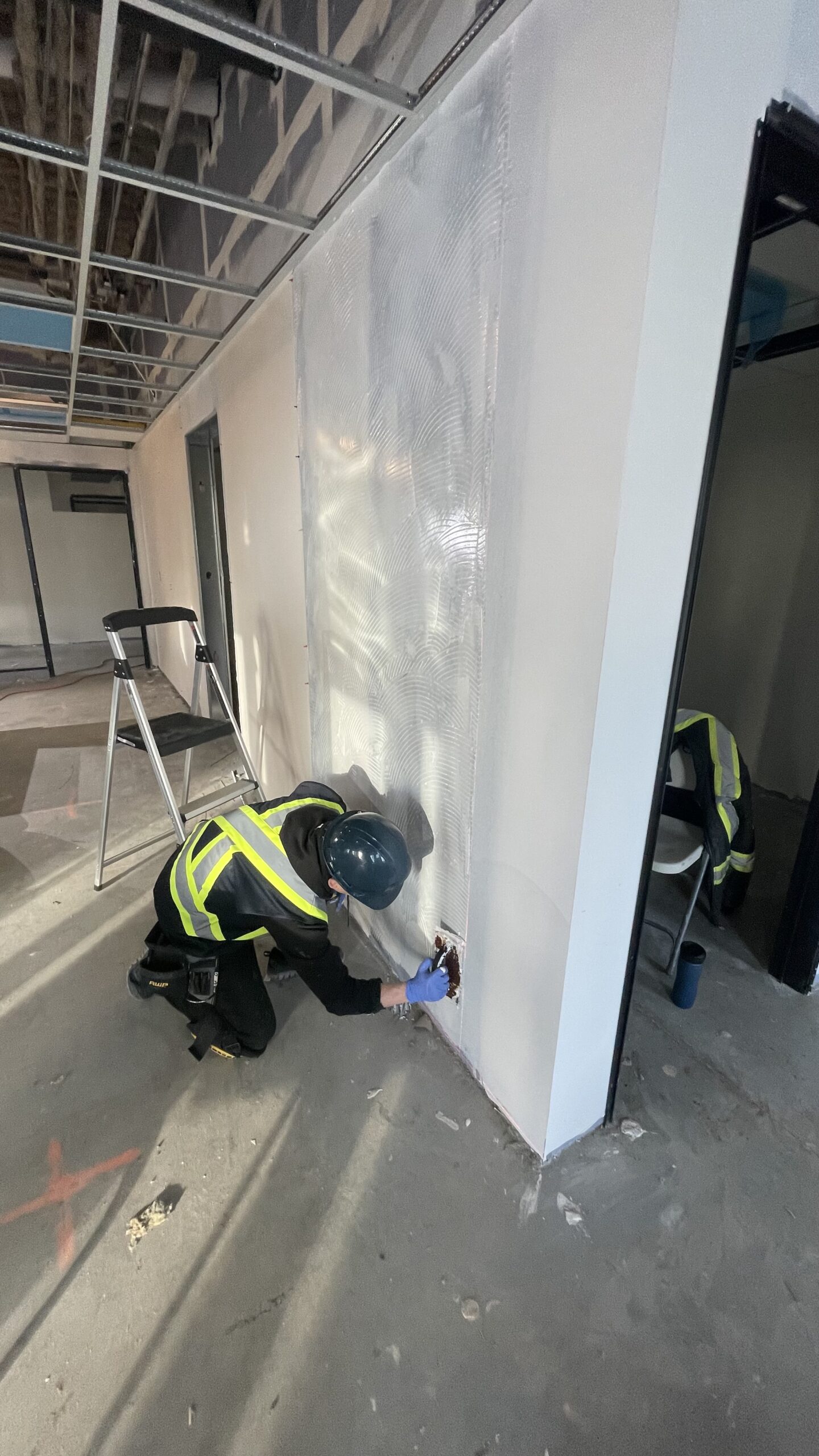 Installer fitting a full-height Acrovyn wall sheet – Halton Centre for Child Care